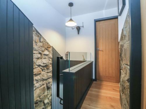a hallway with a stone wall and a wooden door at Seren Fach in Pwllheli