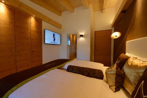 a bedroom with two beds and a tv on the wall at Moar Lodge in Postal