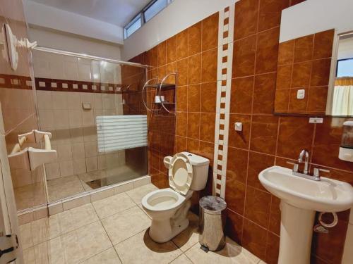 a bathroom with a toilet and a sink at Hotel Safari in Iquitos