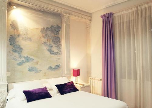 a bedroom with a bed with a painting on the wall at Hostal Terán in Madrid
