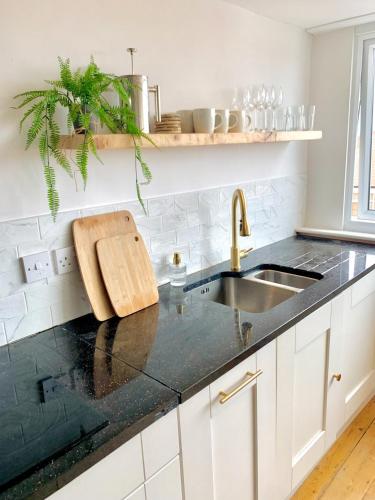 a kitchen with a sink and a black counter top at Escape to Lytham St. Annes in Lytham St Annes
