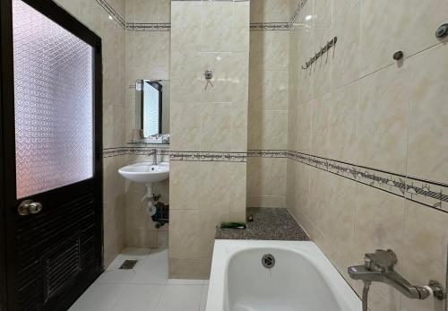 a bathroom with a bath tub and a sink at SEAMOON Hotel in Rạch Giá