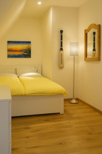 a bedroom with a bed and a guitar on the wall at Kleine Auszeit Pellworm in Pellworm