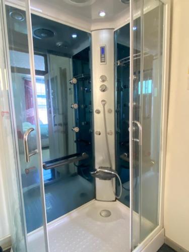 a shower with a glass door in a bathroom at Hostal Cochrane in Valdivia