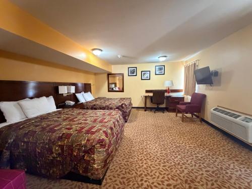a hotel room with a bed and a desk at Regal Inn Coffeyville KS US 169 in Coffeyville
