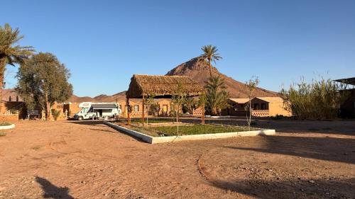 a house with a rv parked in front of it at Taragalte Park - Motorhomes in Zagora
