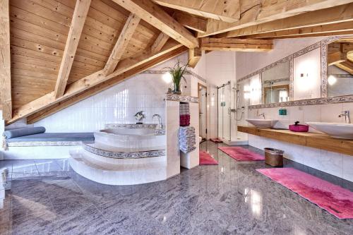 a large bathroom with two sinks and a wooden ceiling at Wally Luxus Lodge im Ferienhaus Magdalena in Mittenwald