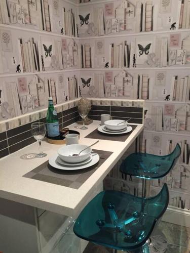 a table with plates and glasses and a blue chair at Apartments at 145 in Southport