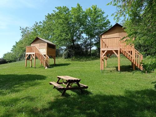 a park with a bench and a play house at Camping La Bâtisse in Réalmont