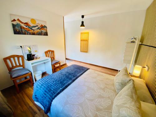 a bedroom with a bed and a desk and chairs at Benvinguts a Casa Nostra in El Pont de Suert
