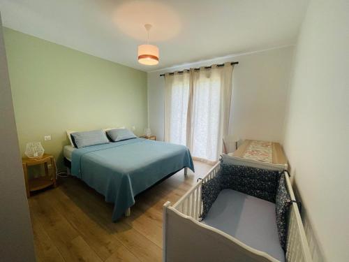 a bedroom with a blue bed and a window at Maison familiale à Ahetze à 10 min des plages in Ahetze