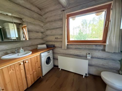 a bathroom with a sink and a washing machine at Domy z Bali nad jeziorem - Leśna Oaza in Międzyrzecz