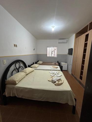 a bedroom with two beds and a window at Jampa Pousada Sb in João Pessoa