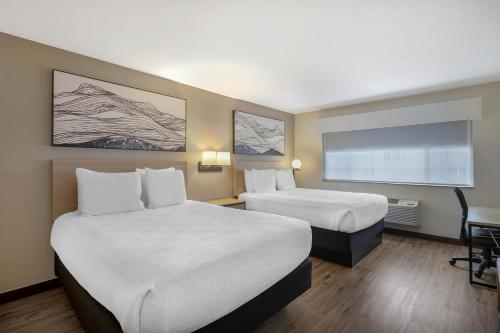 a hotel room with two beds and a large window at Best Western Plus Meridian in Meridian