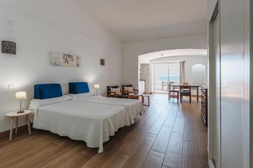 a bedroom with a large white bed and a table at Apartamentos Borda D´Agua in Albufeira