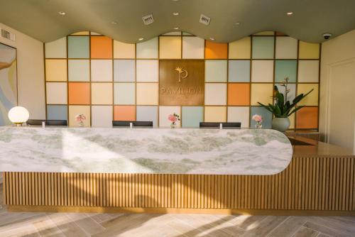 a large marble table in a lobby with a tiled wall at Pavilion Hotel in Avalon