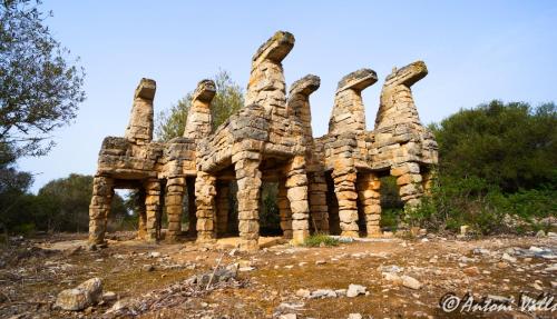 a stone building with four hands carved into it at Residencia Santiago Mallorca in Cala Figuera