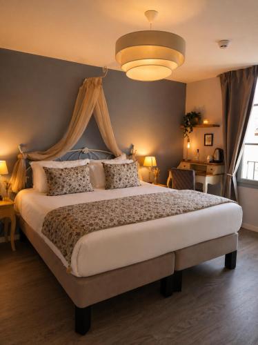 a bedroom with a large bed with a canopy at Hôtel des Augustins - Boutique Hôtel - Restaurant Gastronomique in Saint-Cyprien