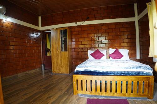 a bedroom with a bed with pink pillows on it at Private Cottage Room Non AC in Ponnampet