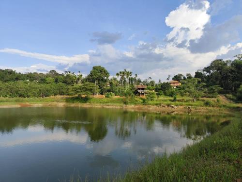 a body of water with trees in the background at Private Cottage Room Non AC in Ponnampet