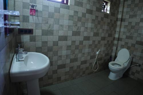 a bathroom with a sink and a toilet at Private Cottage Room Non AC in Ponnampet