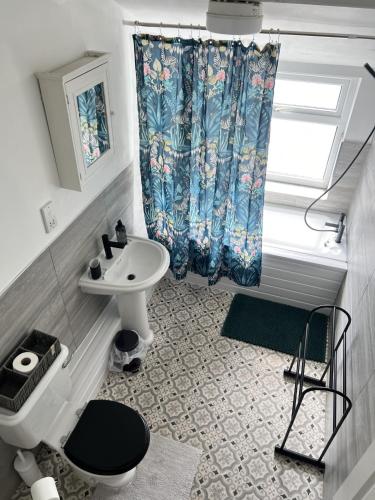 a bathroom with a sink and a toilet and a shower curtain at The Hive 2-Bed Apartment with Kitchen and Private Bathroom in Lively Monton Village - Sleeps 4 - Free WiFi - Parking Nearby in Manchester