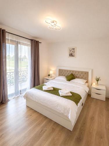 a bedroom with a large bed and a large window at Apartament Nou & Modern în Rădăuți 2 Camere Parcare WiFi in Rădăuţi