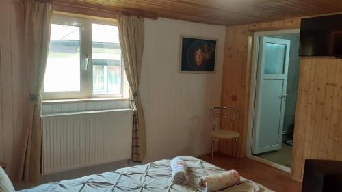 a bedroom with a bed and a window and a chair at Welcoming home on the corner in Slănic