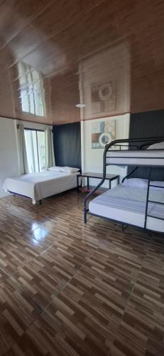 a room with two bunk beds and a wooden floor at House of Dreams in Nicoya