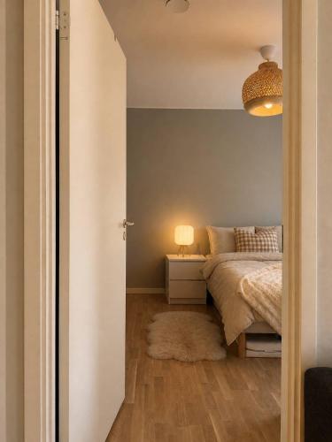 a bedroom with a bed and a table with a lamp at Modern lägenhet i Vasastan in Stockholm