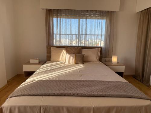 a large bed in a bedroom with a window at City Vibes - Central 3BR Spacious Apartment in Larnaca