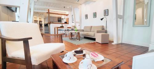 a living room with a chair and a table at Brasseriehof Historisches Fachwerkhaus in Flensburg 115 m2 Innenhof Parkplatz in Flensburg