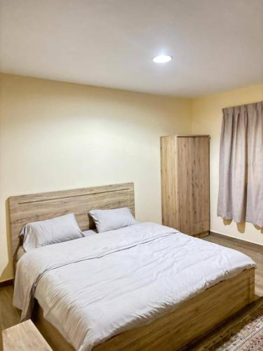 a bedroom with a large bed with white sheets at thedesert08 in Ras al Khaimah