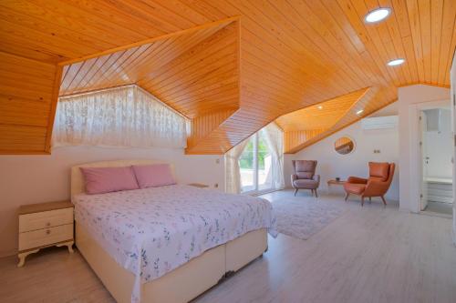 a bedroom with a bed and a wooden ceiling at Villa Calıs 2 in Fethiye