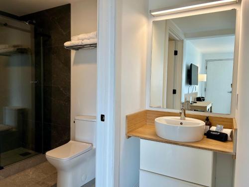 a bathroom with a sink and a toilet and a mirror at The Harbor Inn in Grand Marais