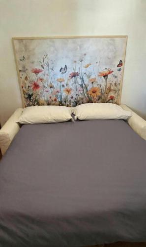 a bed in a bedroom with a painting on the wall at LUCIA s sweet Home in Padova