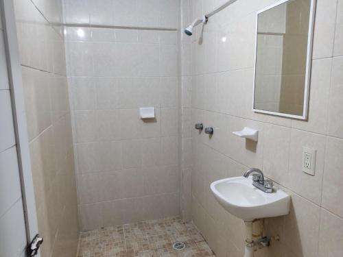 a white bathroom with a sink and a mirror at Centro turístico la playitaa in Chachalacas