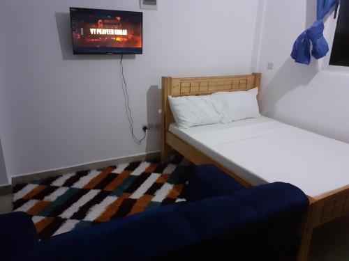 a small room with two beds and a tv at Asante Studio in Mtwapa