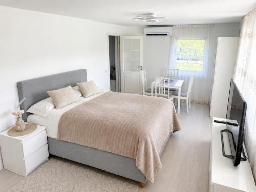 a white bedroom with a bed and a table at D&C Norway in Kristiansand