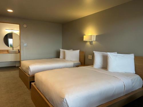 a hotel room with two beds and a mirror at The Harbor Inn in Grand Marais