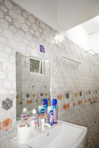 a bathroom with a sink and a mirror at Cozy studio at Kisimani Heights Apartment Mombasa in Mombasa