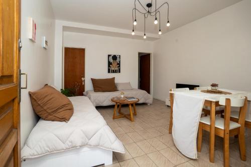 ein Wohnzimmer mit Sofa und Tisch in der Unterkunft DEPARTAMENTO cerca de CABA hasta 4 personas Parking Gratis Patio ideal familias estadias cortas por Trabajo Recitales Salud y Capacitaciones in Martínez
