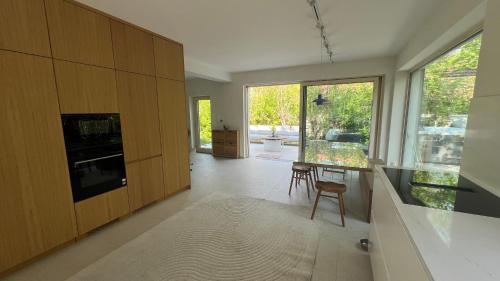 a kitchen with wooden cabinets and a table and chairs at Fészek Villa in Balatonszemes