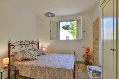 a bedroom with a bed and a window at Villa con piscina Seychelles del Salento in Marina di Pescoluse