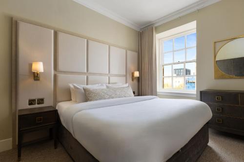 a large white bed in a room with a window at Blythswood Square Apartments in Glasgow