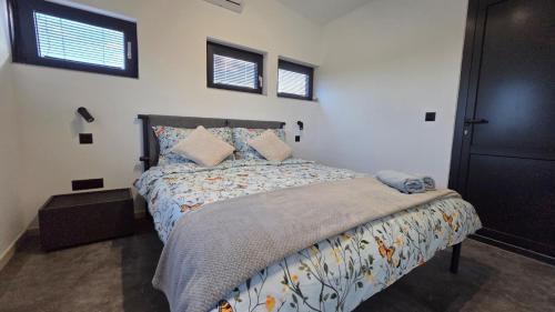 a bedroom with a bed and two windows at Hangar Hangout by the Lake in Priles