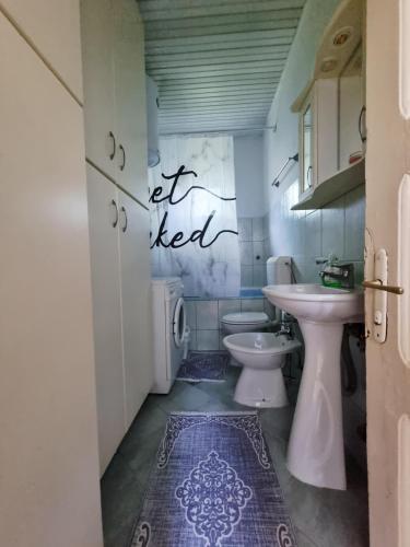 a bathroom with a sink and a toilet at Artisan Center Apartment Peja in Peje