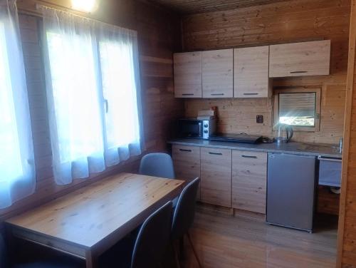 a kitchen with wooden cabinets and a wooden table at Chata Čertovy hlavy in Želízy