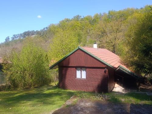 a small red house in the middle of a yard at Chata Čertovy hlavy in Želízy