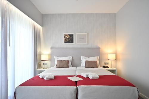 a bedroom with two large beds with red blanket at My Charm Lisbon Suites in Lisbon